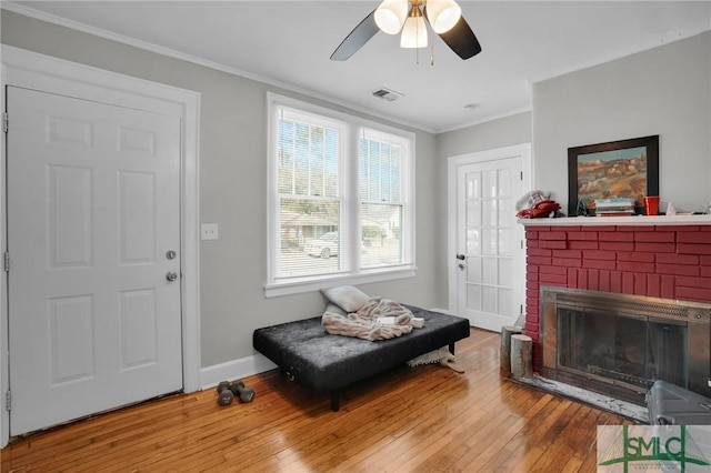 sitting room featuring visible vents, crown molding, baseboards, hardwood / wood-style floors, and a fireplace