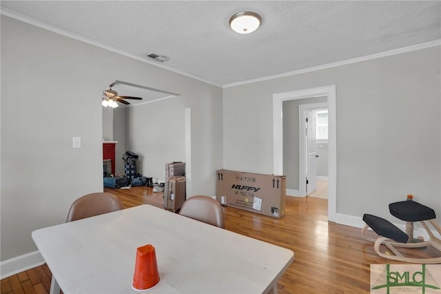 dining room featuring visible vents, baseboards, a textured ceiling, and light wood-style flooring