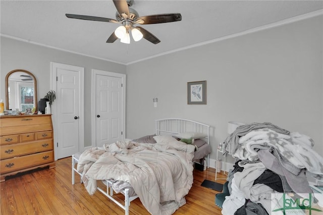 bedroom with a ceiling fan, light wood-style floors, and crown molding