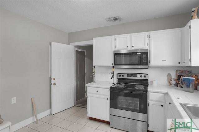 kitchen with visible vents, white cabinetry, stainless steel appliances, and light countertops