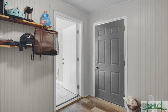 doorway to outside with crown molding and wood finished floors