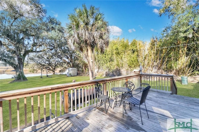 wooden terrace with a water view and a lawn