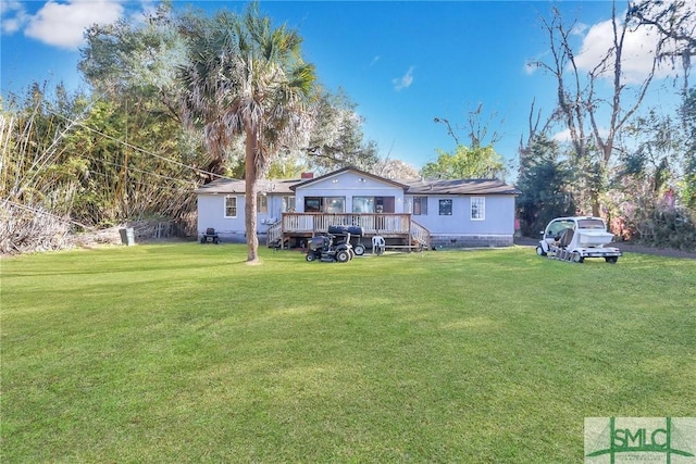 back of house with crawl space, a wooden deck, and a lawn