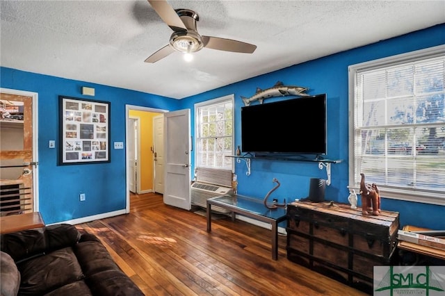 living area with ceiling fan, baseboards, a textured ceiling, and hardwood / wood-style floors