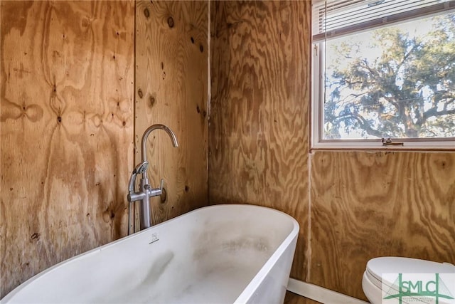 bathroom with a sink, toilet, and a freestanding bath
