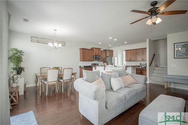 living area with recessed lighting, visible vents, dark wood-type flooring, and ceiling fan with notable chandelier