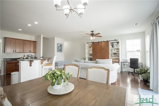 dining area featuring visible vents, ceiling fan with notable chandelier, wood finished floors, recessed lighting, and a barn door