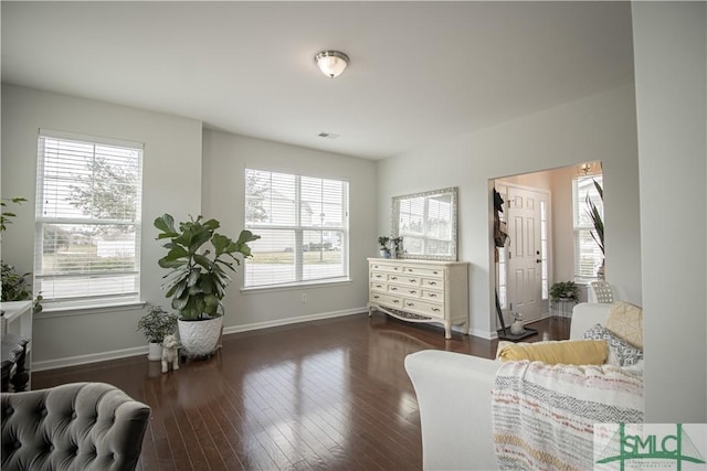 sitting room featuring baseboards, visible vents, wood-type flooring, and a wealth of natural light