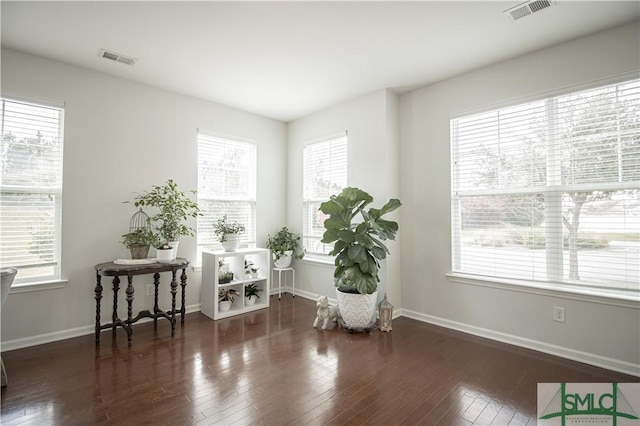 living area featuring visible vents, baseboards, and hardwood / wood-style flooring