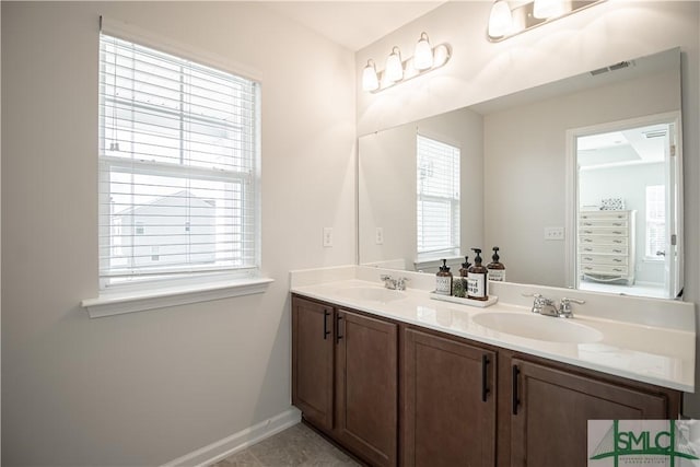 full bathroom featuring double vanity, baseboards, visible vents, and a sink