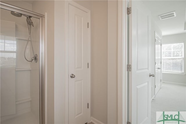 bathroom featuring visible vents, baseboards, and a shower stall