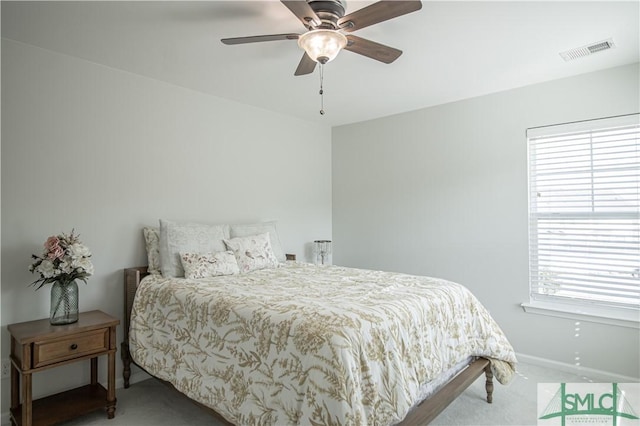 carpeted bedroom with visible vents, a ceiling fan, and baseboards