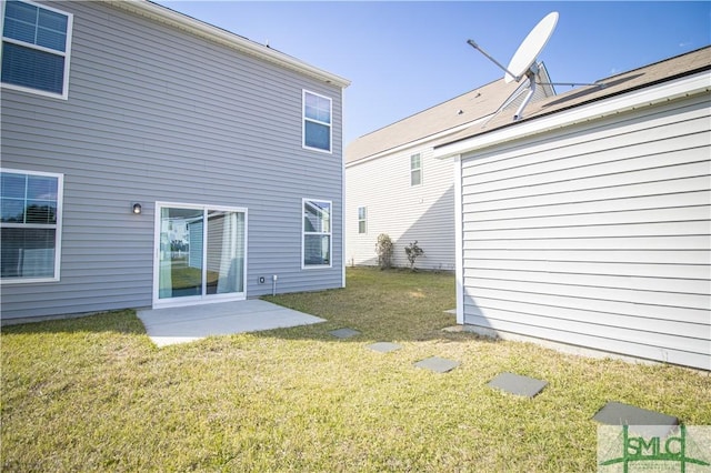 rear view of house featuring a yard and a patio area
