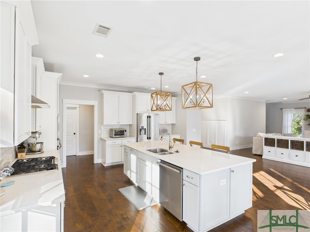 kitchen with ornamental molding, decorative backsplash, light countertops, a sink, and appliances with stainless steel finishes