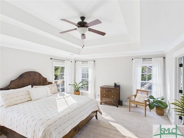 bedroom featuring crown molding, a ceiling fan, carpet, and a tray ceiling