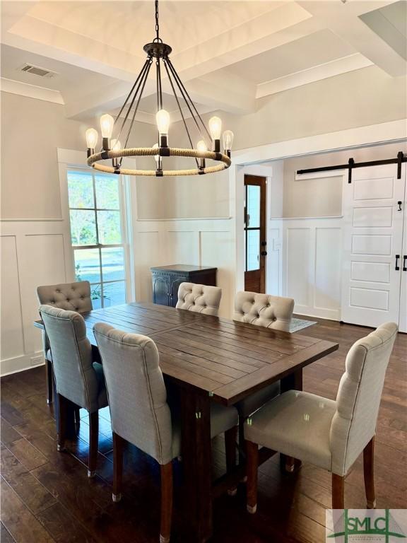 dining room featuring beam ceiling, a decorative wall, a notable chandelier, and a barn door