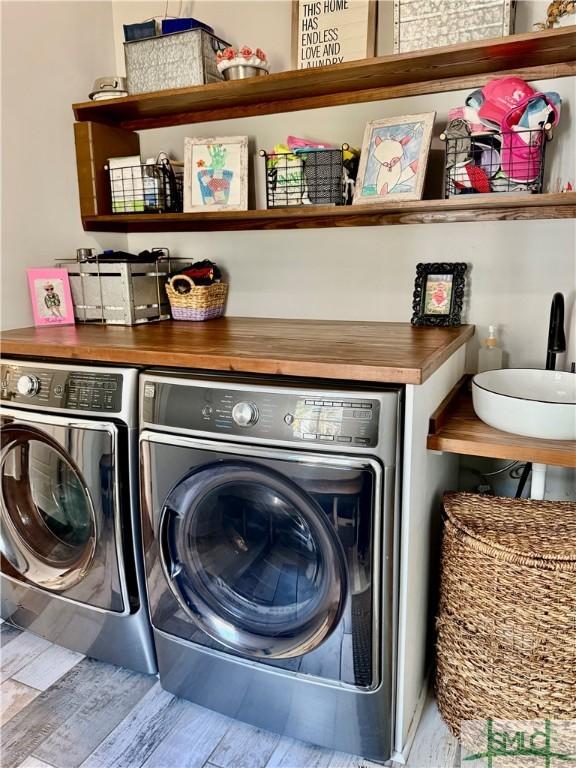 laundry area featuring laundry area, wood finished floors, and washing machine and clothes dryer