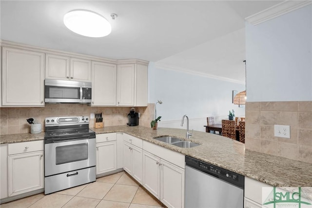 kitchen featuring backsplash, crown molding, appliances with stainless steel finishes, light tile patterned flooring, and a sink