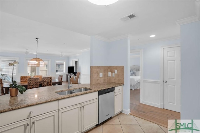 kitchen featuring a sink, stainless steel dishwasher, and crown molding