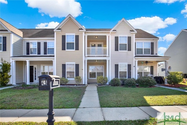 multi unit property with a balcony and a front yard