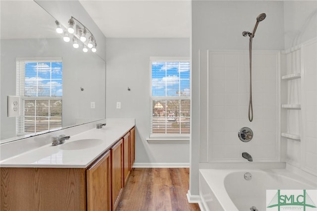 bathroom with baseboards, vanity,  shower combination, and wood finished floors