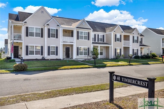 view of property with a residential view and a front lawn