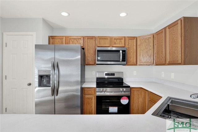 kitchen featuring a sink, appliances with stainless steel finishes, recessed lighting, and light countertops