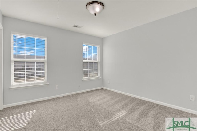 unfurnished room with visible vents, baseboards, and carpet