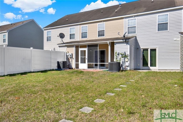 rear view of property featuring cooling unit, a sunroom, a yard, and fence