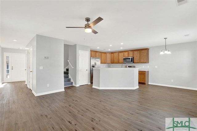 kitchen featuring light countertops, wood finished floors, open floor plan, and appliances with stainless steel finishes