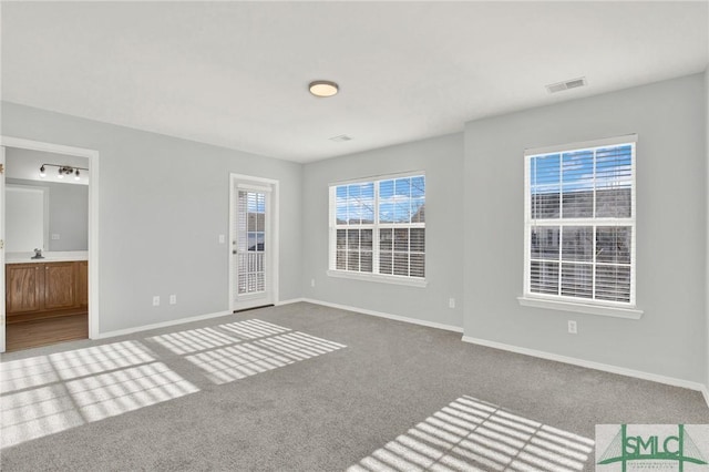 interior space with baseboards, visible vents, and a sink