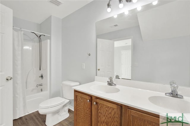 full bathroom with double vanity, toilet, visible vents, and a sink