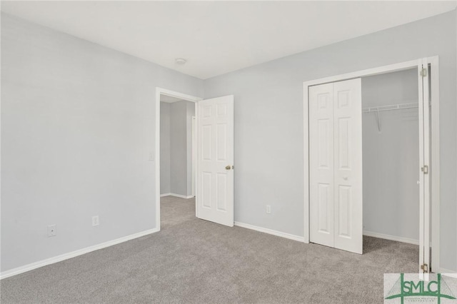 unfurnished bedroom with a closet, baseboards, and carpet floors