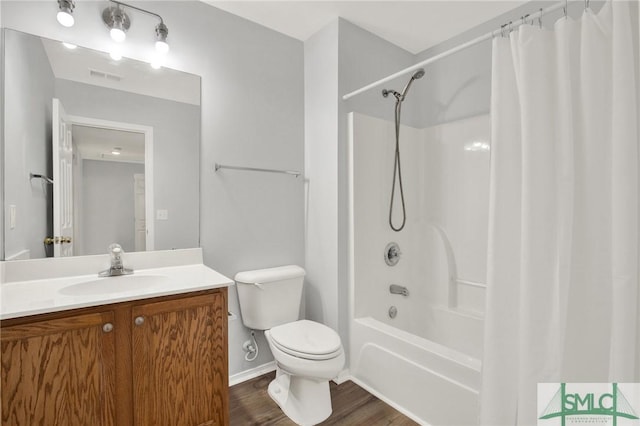 bathroom featuring visible vents, shower / bath combo with shower curtain, toilet, wood finished floors, and vanity