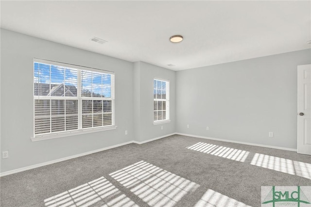 carpeted empty room featuring visible vents and baseboards