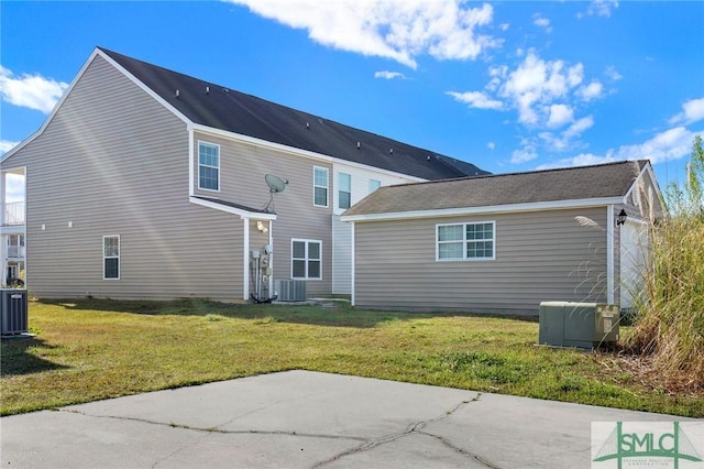 back of property with a patio, a lawn, and central AC unit