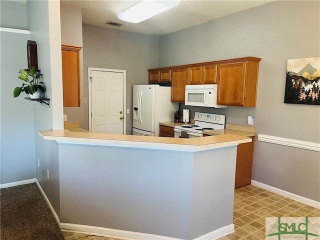 270 Lancaster Way, Richmond Hill, GA 31324 - kitchen featuring visible vents, baseboards, light countertops, brown cabinetry, and white appliances
