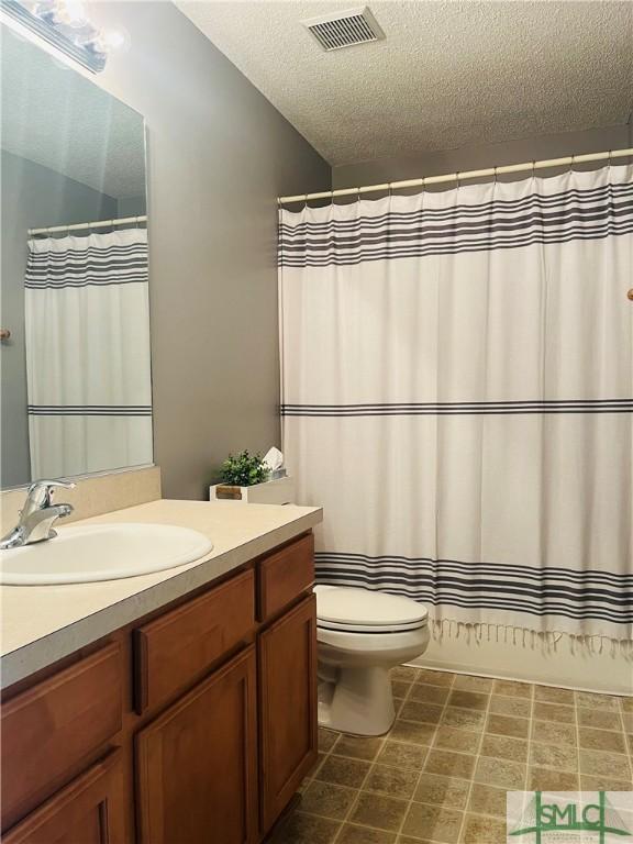 270 Lancaster Way, Richmond Hill, GA 31324 - full bath with visible vents, curtained shower, toilet, vanity, and a textured ceiling