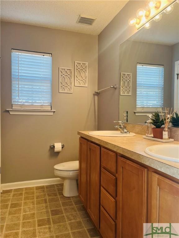 270 Lancaster Way, Richmond Hill, GA 31324 - full bath with visible vents, toilet, double vanity, a wealth of natural light, and a sink