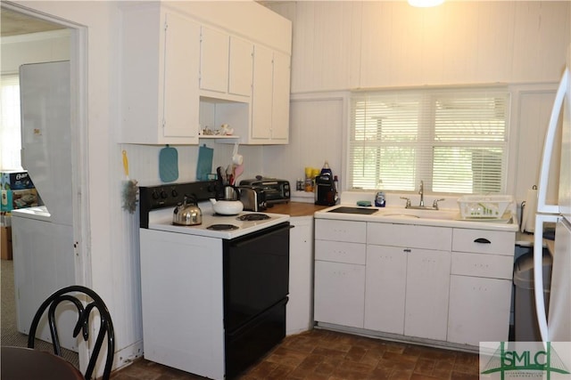 kitchen featuring a sink, electric range oven, white cabinets, light countertops, and brick floor