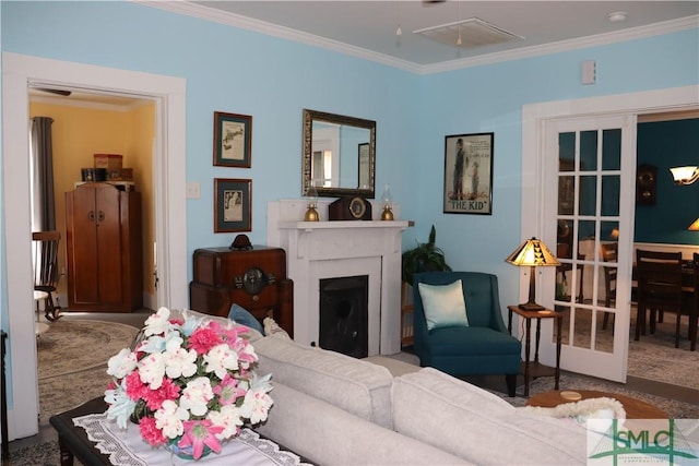 carpeted living room featuring attic access, a fireplace, and ornamental molding