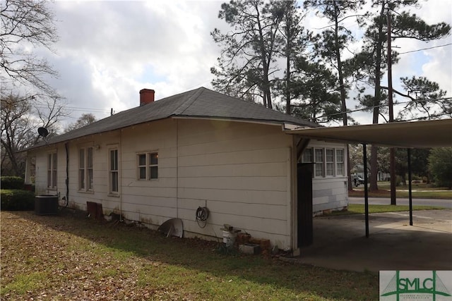 view of home's exterior featuring cooling unit and a chimney