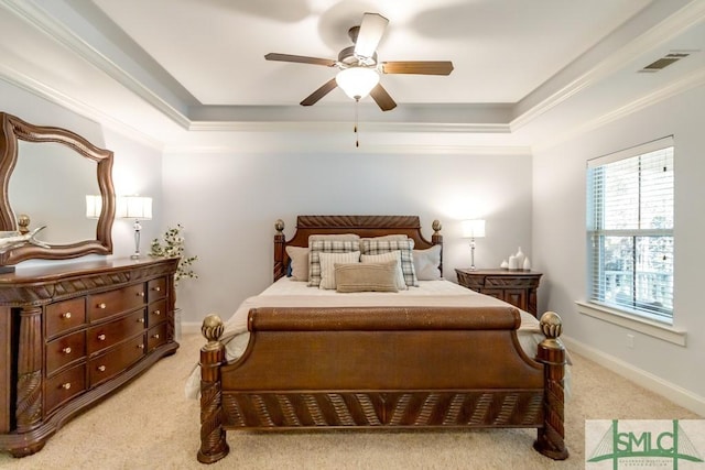 bedroom with baseboards, crown molding, and a raised ceiling