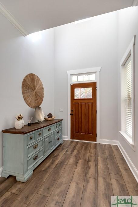 foyer with dark wood-type flooring and baseboards