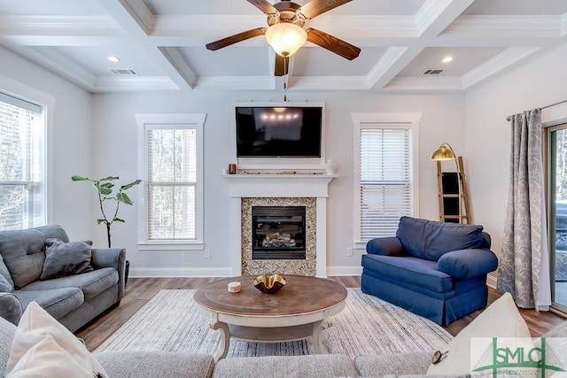 living area with visible vents, baseboards, beam ceiling, and wood finished floors