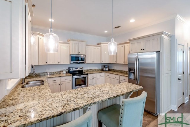 kitchen featuring ornamental molding, a peninsula, light stone countertops, appliances with stainless steel finishes, and a sink