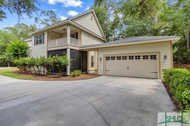 view of front of property with driveway, a balcony, and an attached garage