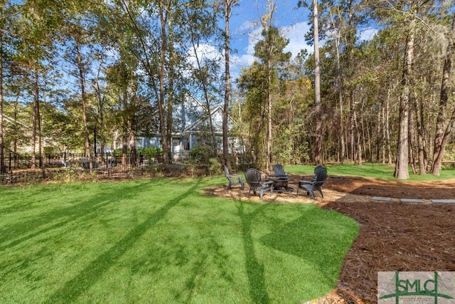 view of yard with a fire pit and fence