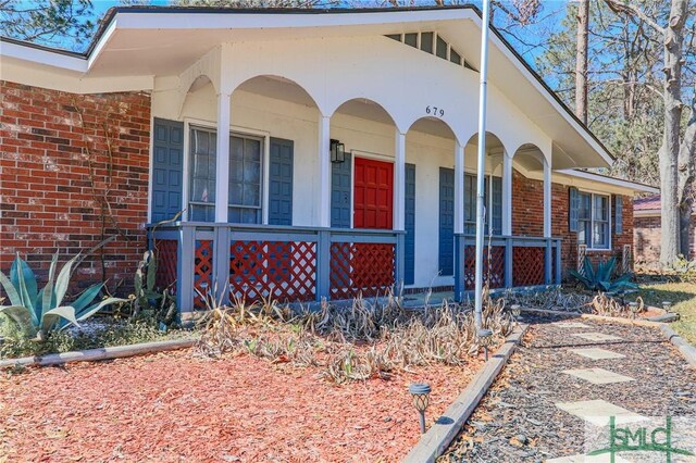 view of front of house with brick siding and covered porch