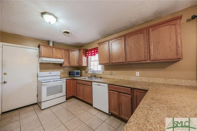 kitchen featuring under cabinet range hood, white appliances, light countertops, and a sink